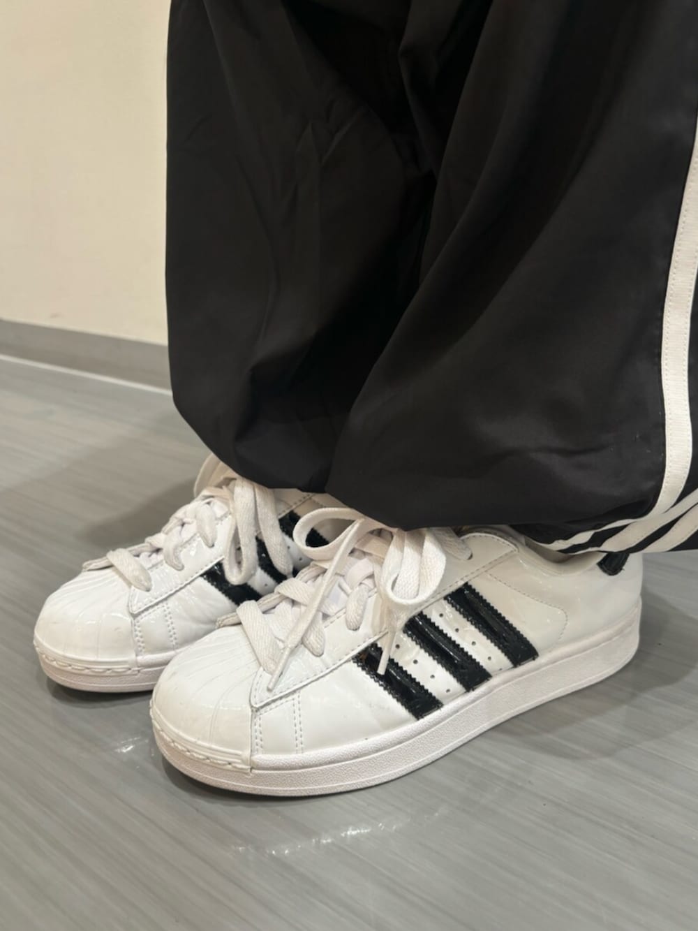 ホワイト系のTシャツ/カットソー、ホワイト系のショルダーバッグ、ブラック系のスウェットパンツを着用したレディースの夏コーディネートの4枚目の写真