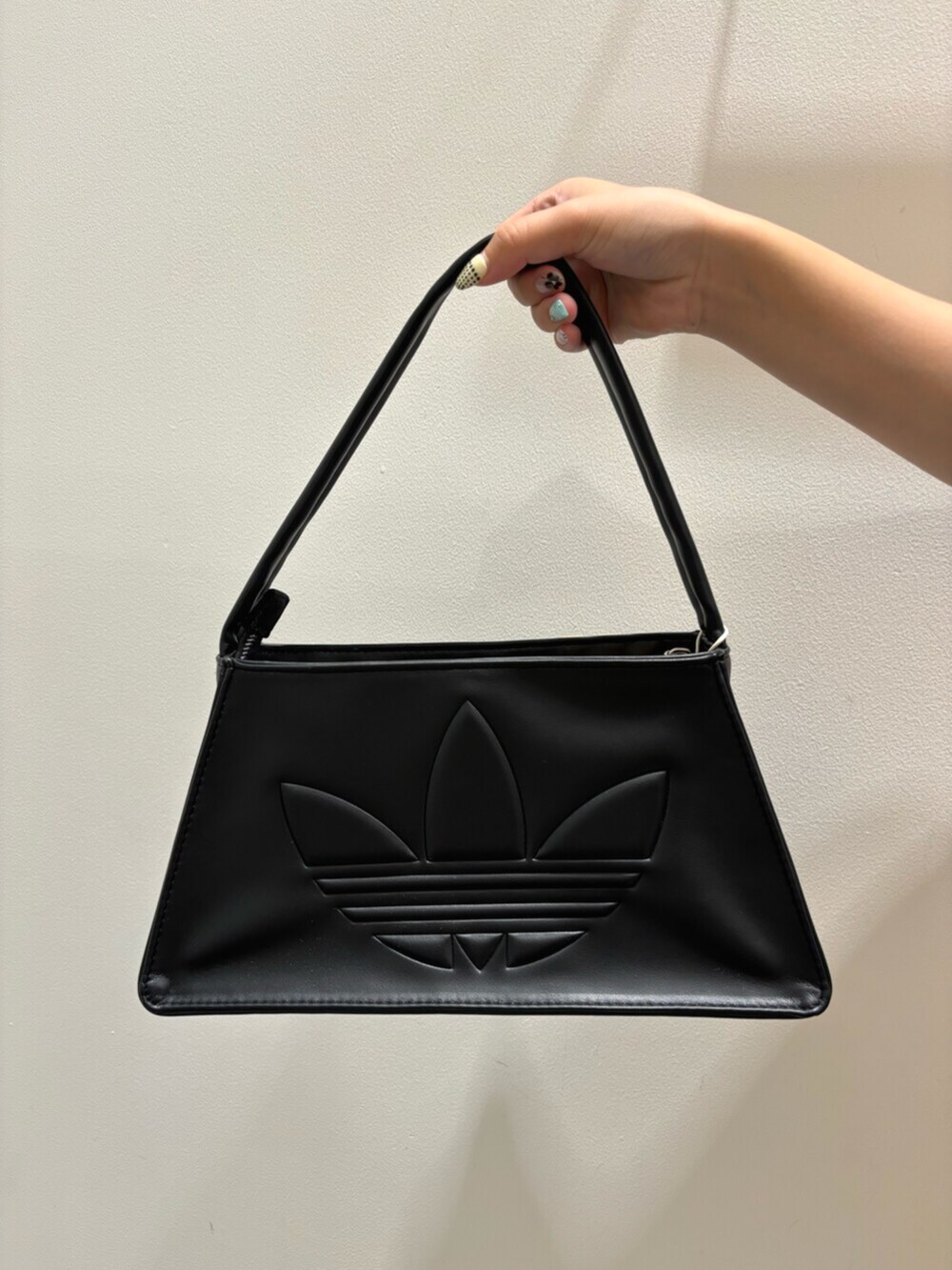 ブルー系のベスト、ブラック系のショルダーバッグ、ホワイト系のシューズを着用したレディースの秋コーディネートの4枚目の写真