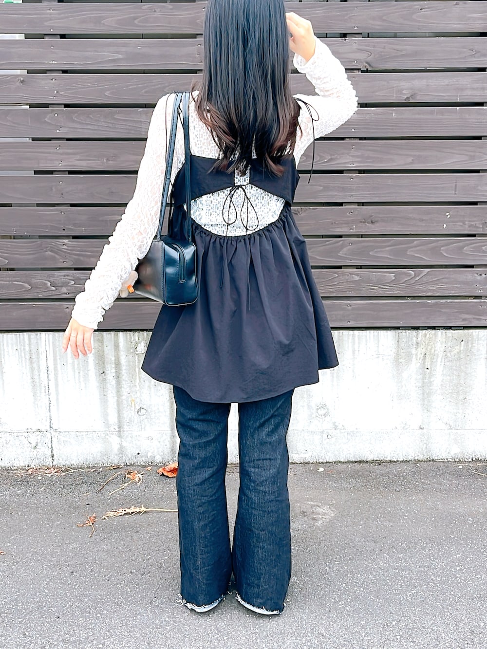 ブラック系のパンプス、ホワイト系のTシャツ/カットソー、ブラック系のデニムパンツを着用したレディースの秋コーディネートの2枚目の写真