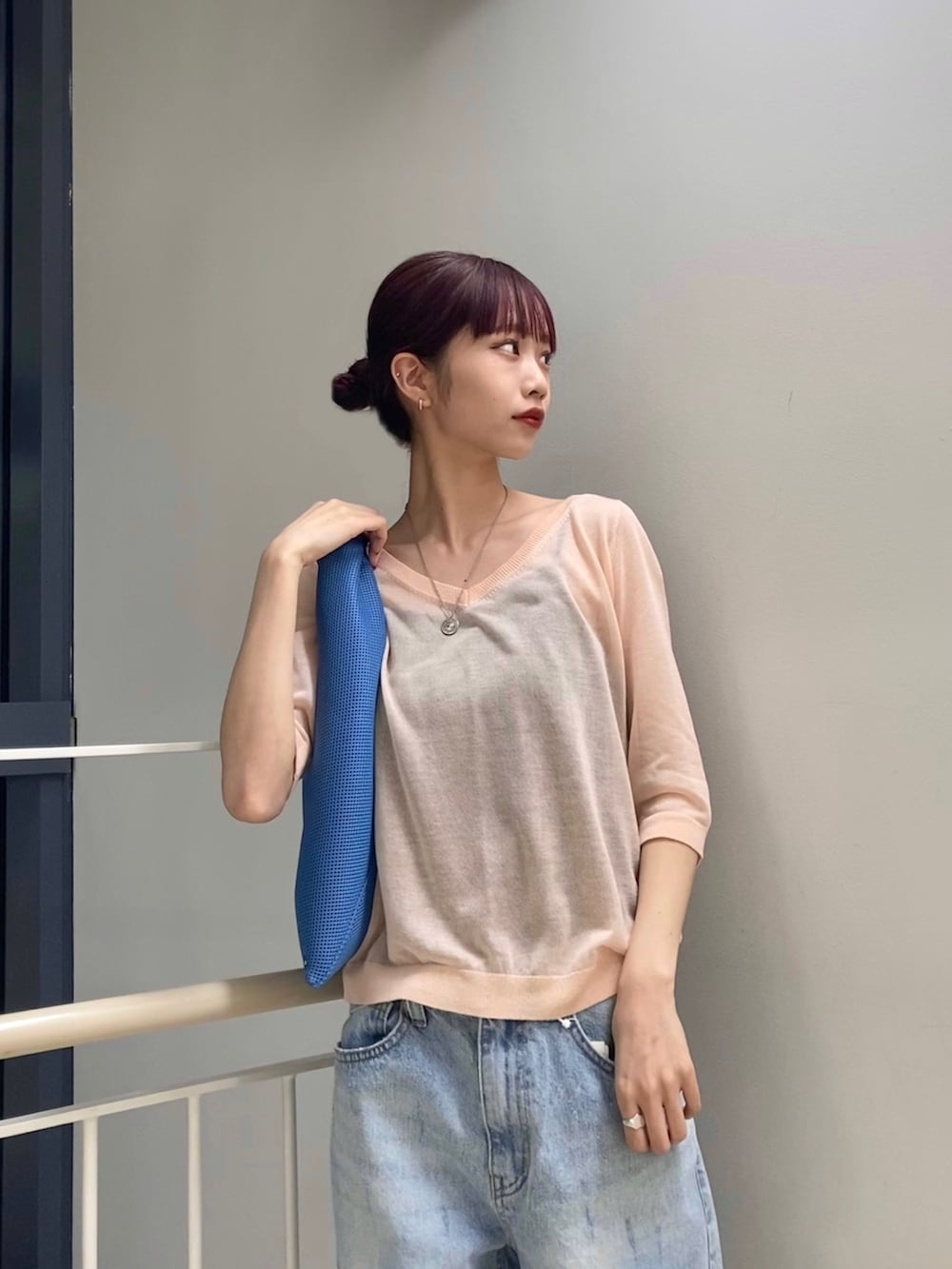 ピンク系のニット/セーター、ブルー系のパンツ、ブラック系のサンダルを着用したレディースの冬コーディネートの2枚目の写真