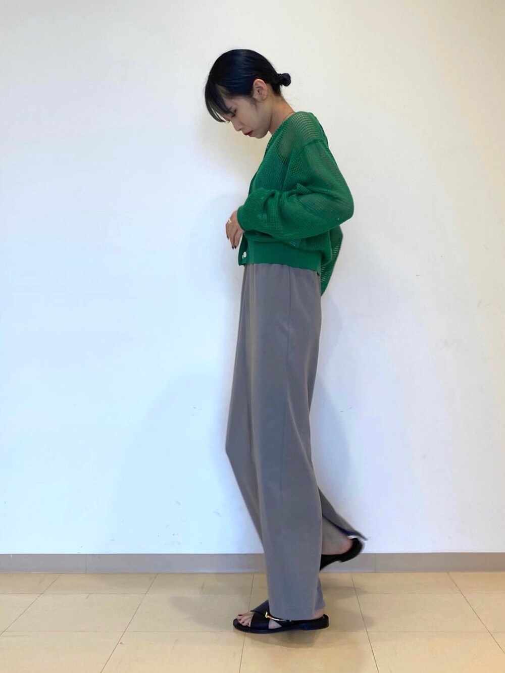 グレー系のワンピース、グリーン系のカーディガン/ボレロを着用したレディースの春コーディネートの4枚目の写真