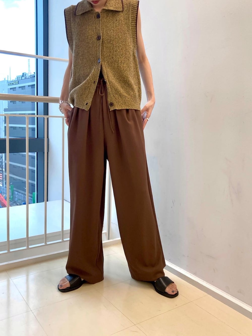 ブラウン系のその他パンツ、ブラウン系のベスト、ブラック系のサンダルを着用したレディースの夏コーディネートの3枚目の写真
