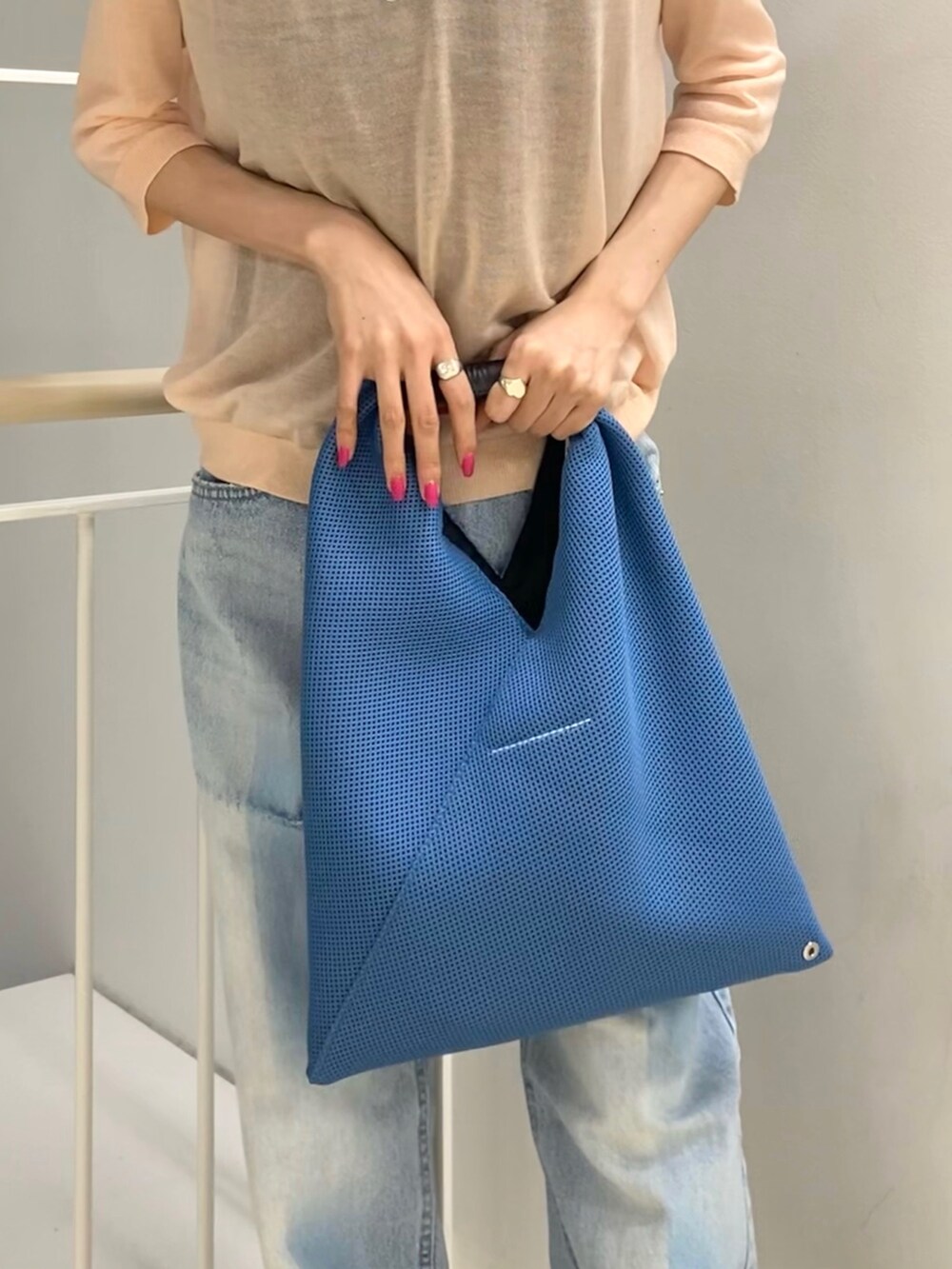 ピンク系のニット/セーター、ブルー系のパンツ、ブラック系のサンダルを着用したレディースの冬コーディネートの4枚目の写真