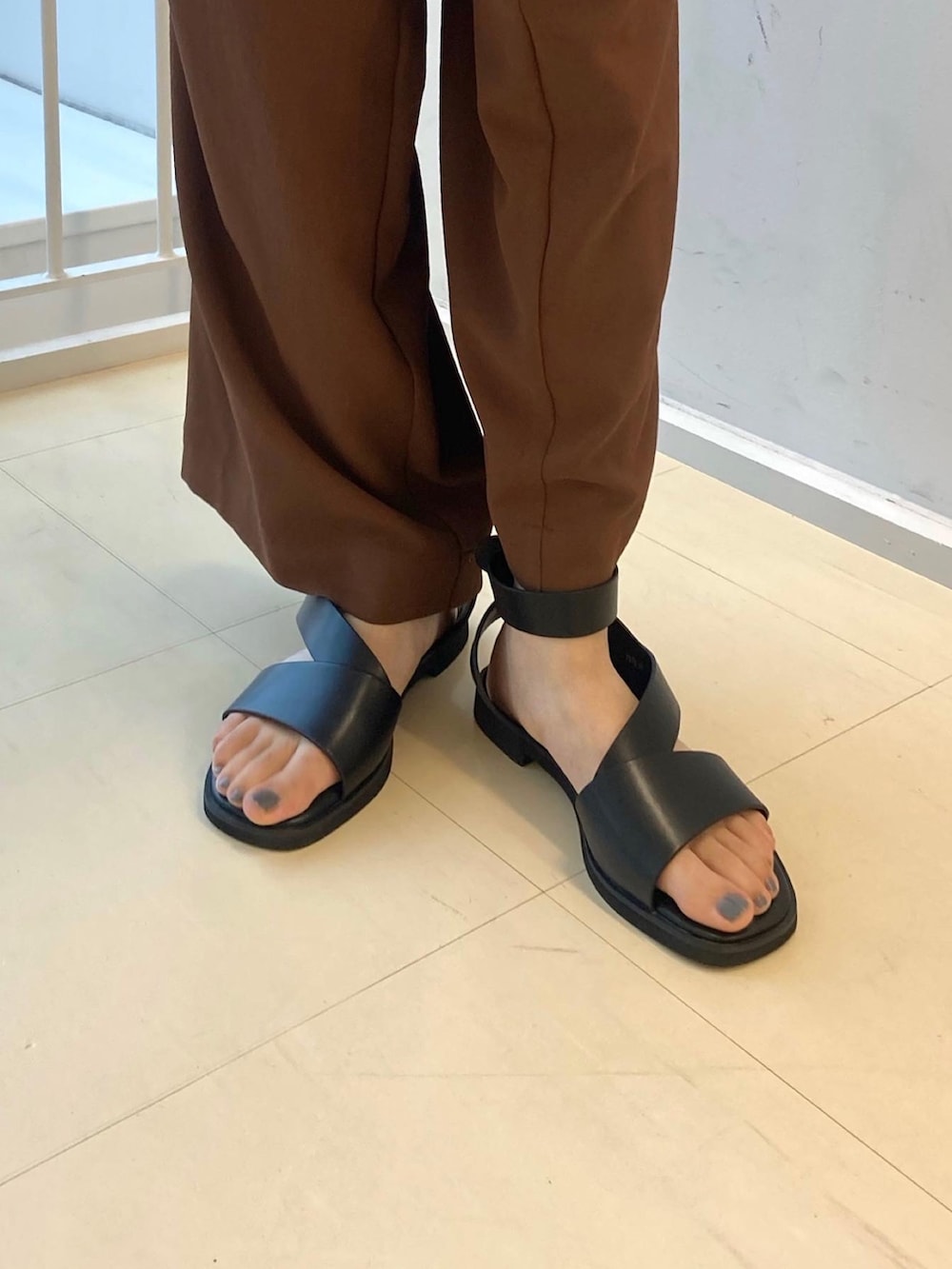 ブラウン系のその他パンツ、ブラウン系のベスト、ブラック系のサンダルを着用したレディースの夏コーディネートの5枚目の写真