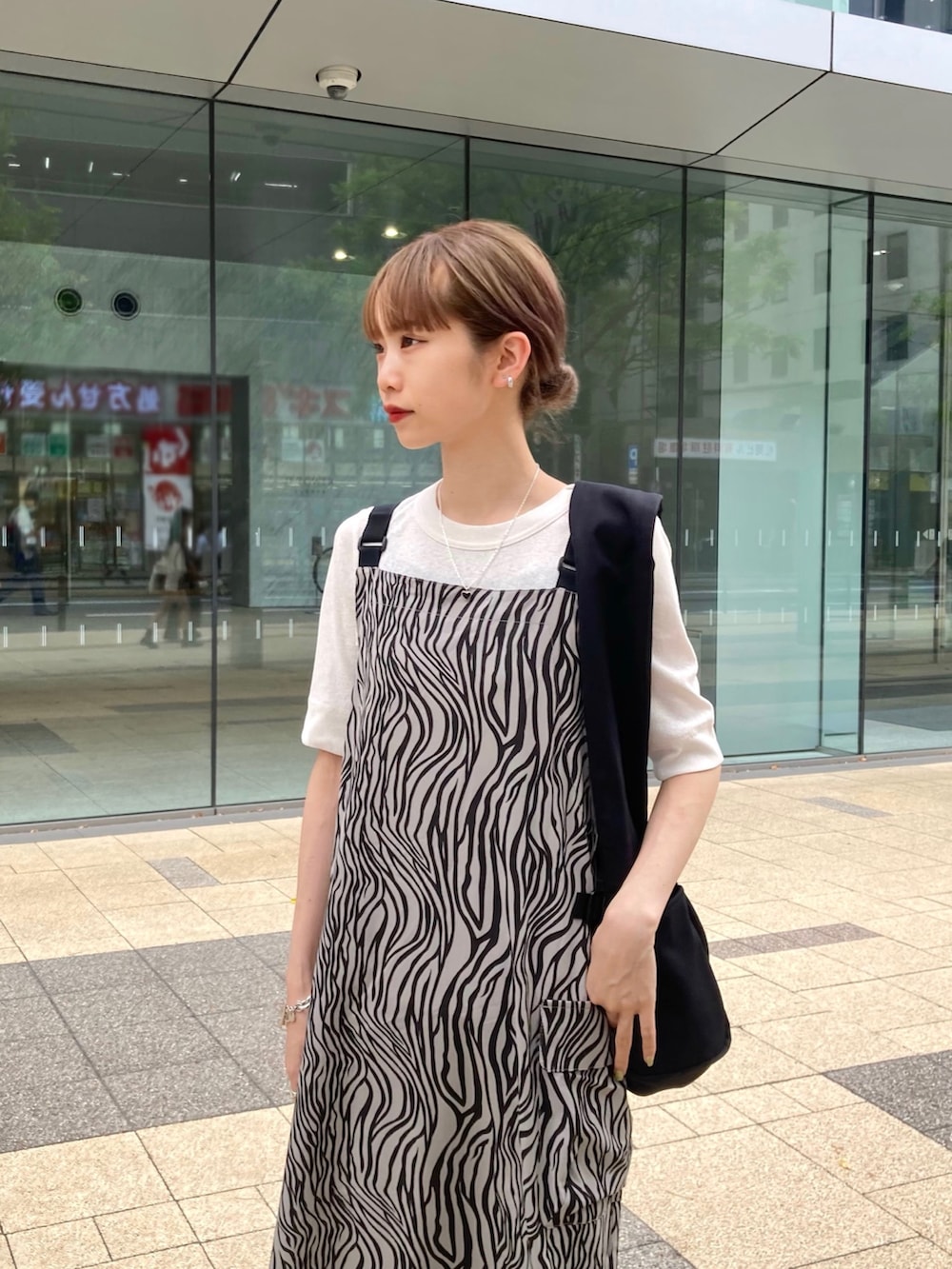 その他のワンピース、ホワイト系のTシャツ/カットソー、ブラック系のショルダーバッグを着用したレディースの春コーディネートの2枚目の写真