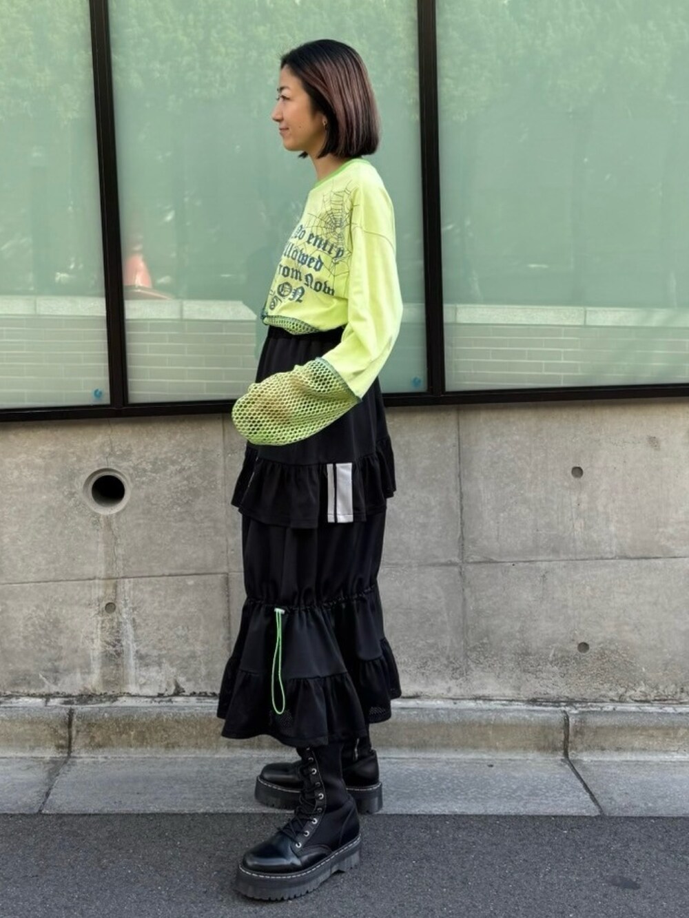 ブラック系のスカート、グリーン系のTシャツ/カットソーを着用したレディースの春コーディネートの3枚目の写真