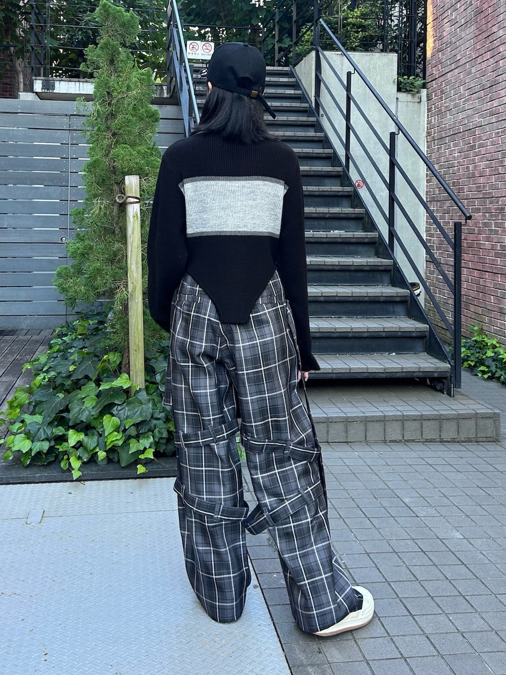 グレー系のその他パンツ、ブラック系のニット/セーター、ブラック系のキャップを着用したレディースの秋コーディネートの5枚目の写真