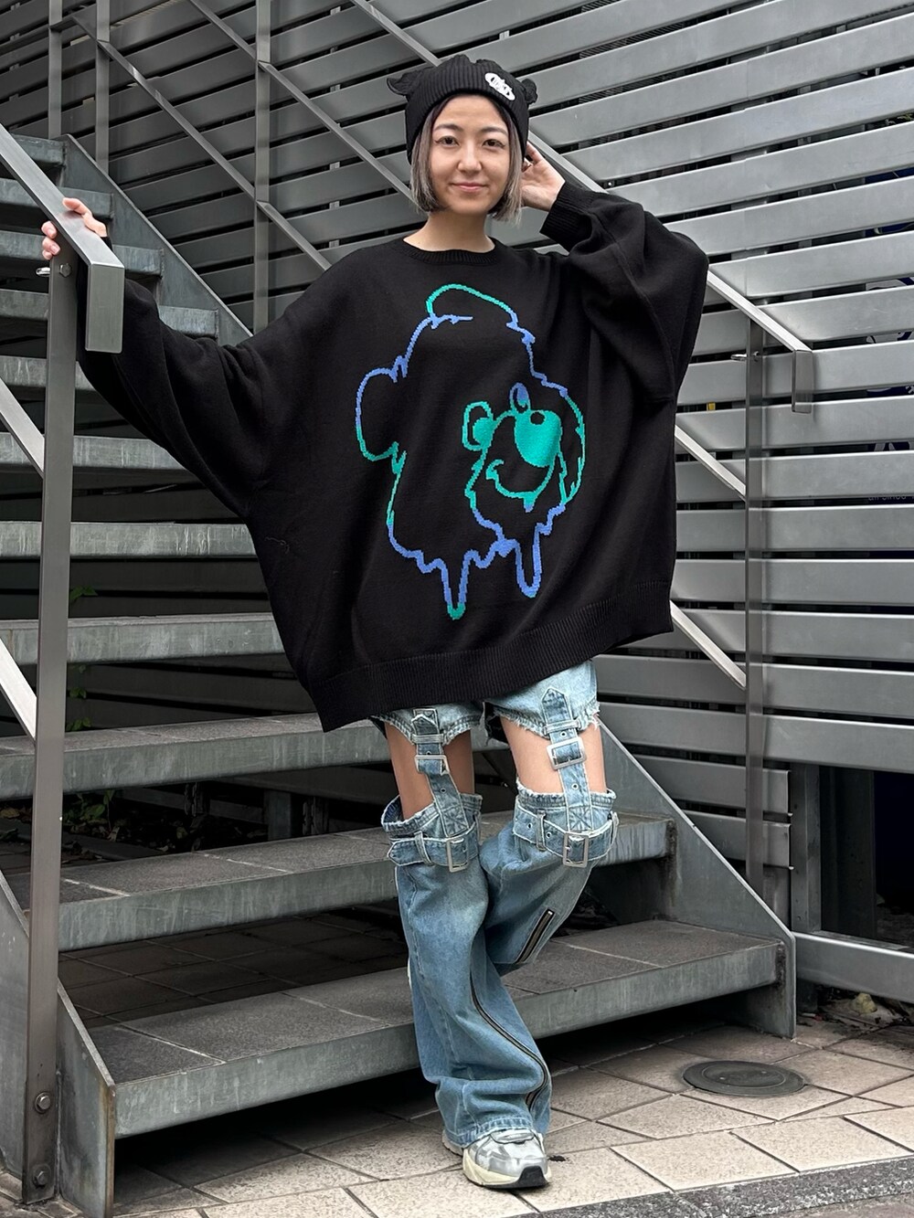 ブラック系のニット/セーター、ブルー系のデニムパンツ、シルバー系のシューズを着用したレディースの秋コーディネートの2枚目の写真