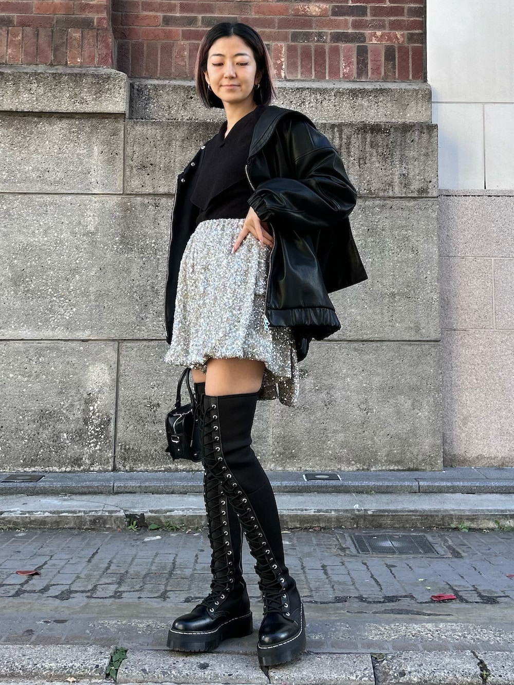 ブラック系のその他アウター、ブラック系のニット/セーター、シルバー系のその他パンツを着用したレディースの冬コーディネートの2枚目の写真