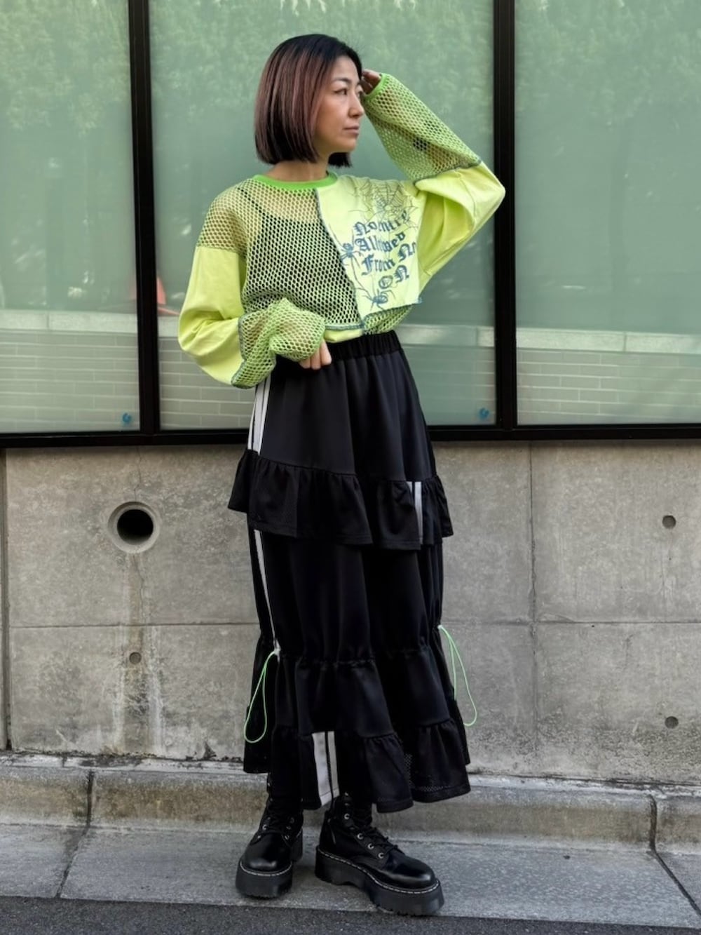 ブラック系のスカート、グリーン系のTシャツ/カットソーを着用したレディースの春コーディネートの2枚目の写真