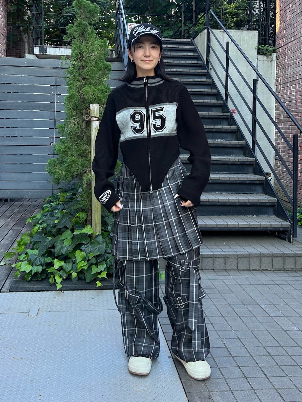 グレー系のその他パンツ、ブラック系のニット/セーター、ブラック系のキャップを着用したレディースの秋コーディネートの2枚目の写真