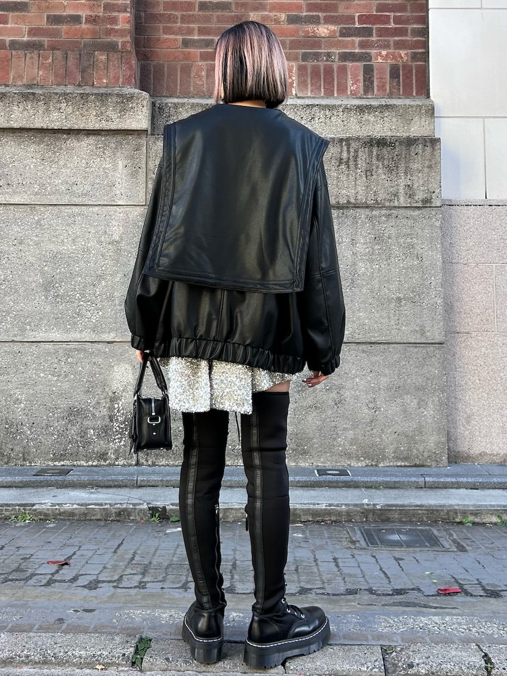 ブラック系のその他アウター、ブラック系のニット/セーター、シルバー系のその他パンツを着用したレディースの冬コーディネートの4枚目の写真