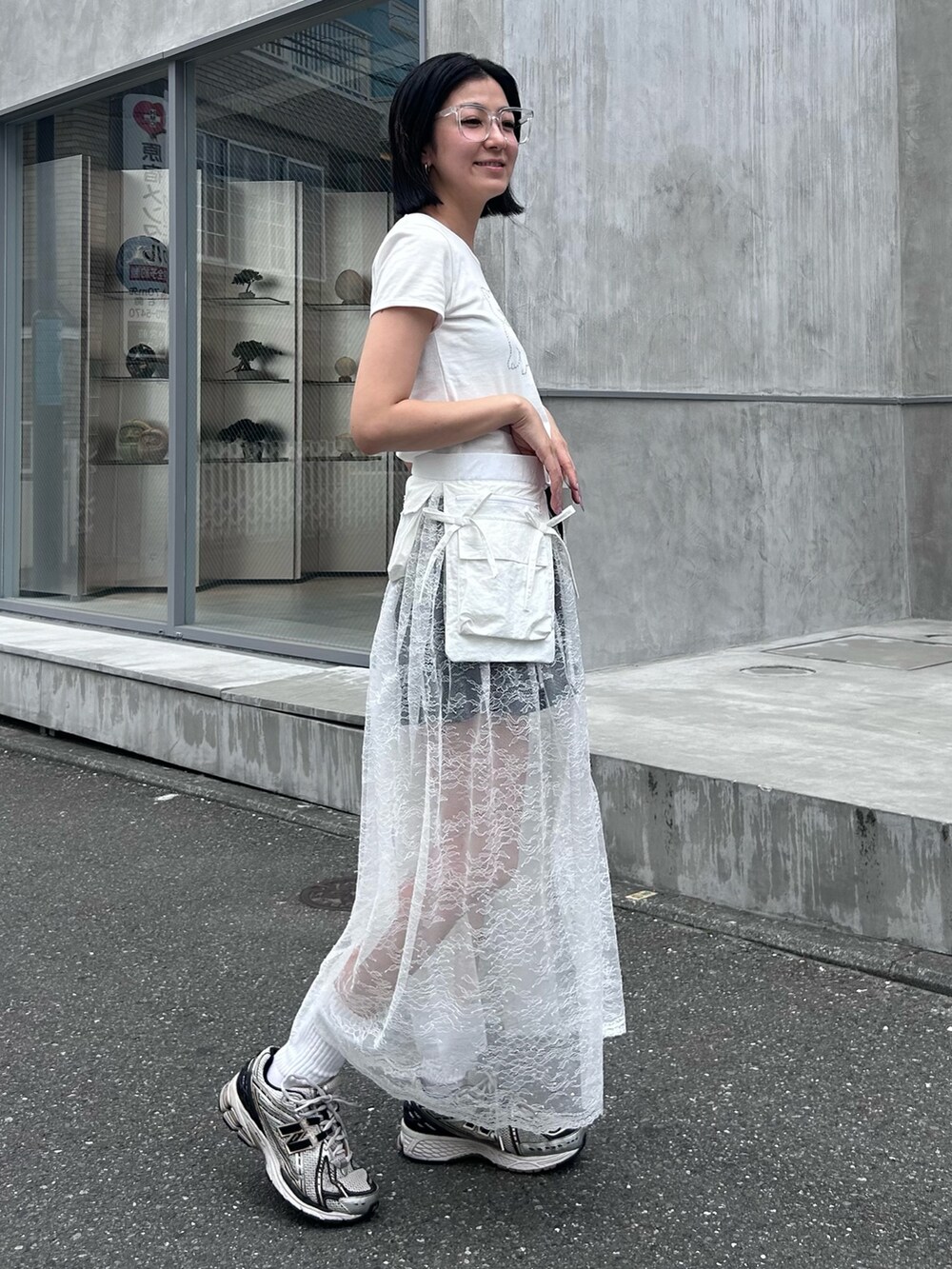 ブラック系のその他パンツ、ホワイト系のスカート、ホワイト系のTシャツ/カットソーを着用したレディースの夏コーディネートの4枚目の写真