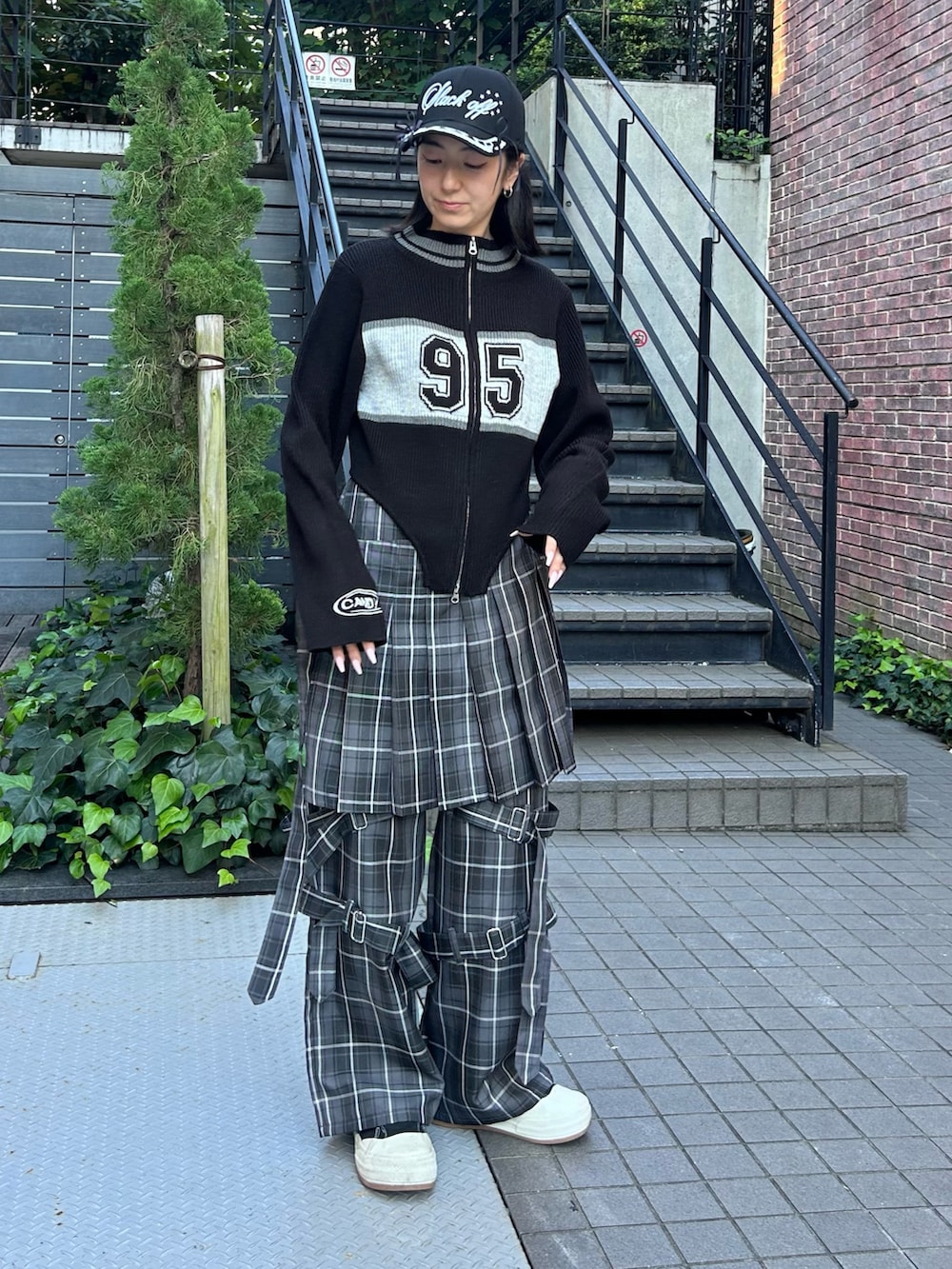 グレー系のその他パンツ、ブラック系のニット/セーター、ブラック系のキャップを着用したレディースの秋コーディネートの4枚目の写真