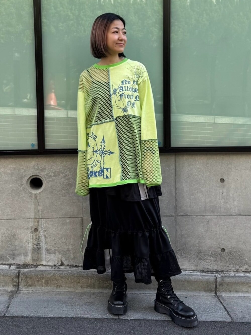 ブラック系のスカート、グリーン系のTシャツ/カットソーを着用したレディースの春コーディネートの5枚目の写真