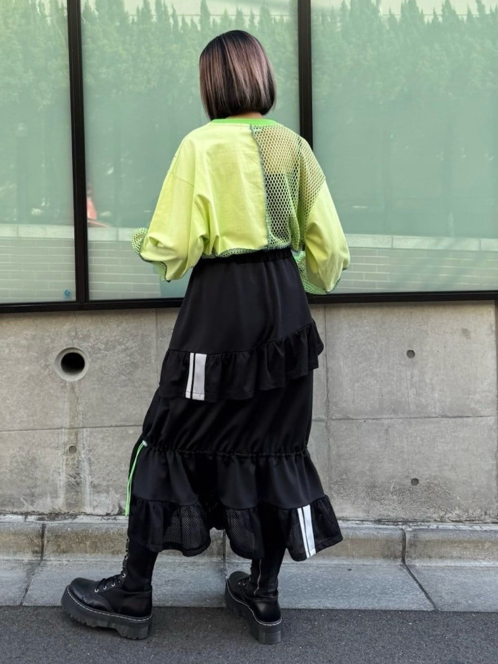 ブラック系のスカート、グリーン系のTシャツ/カットソーを着用したレディースの春コーディネートの4枚目の写真