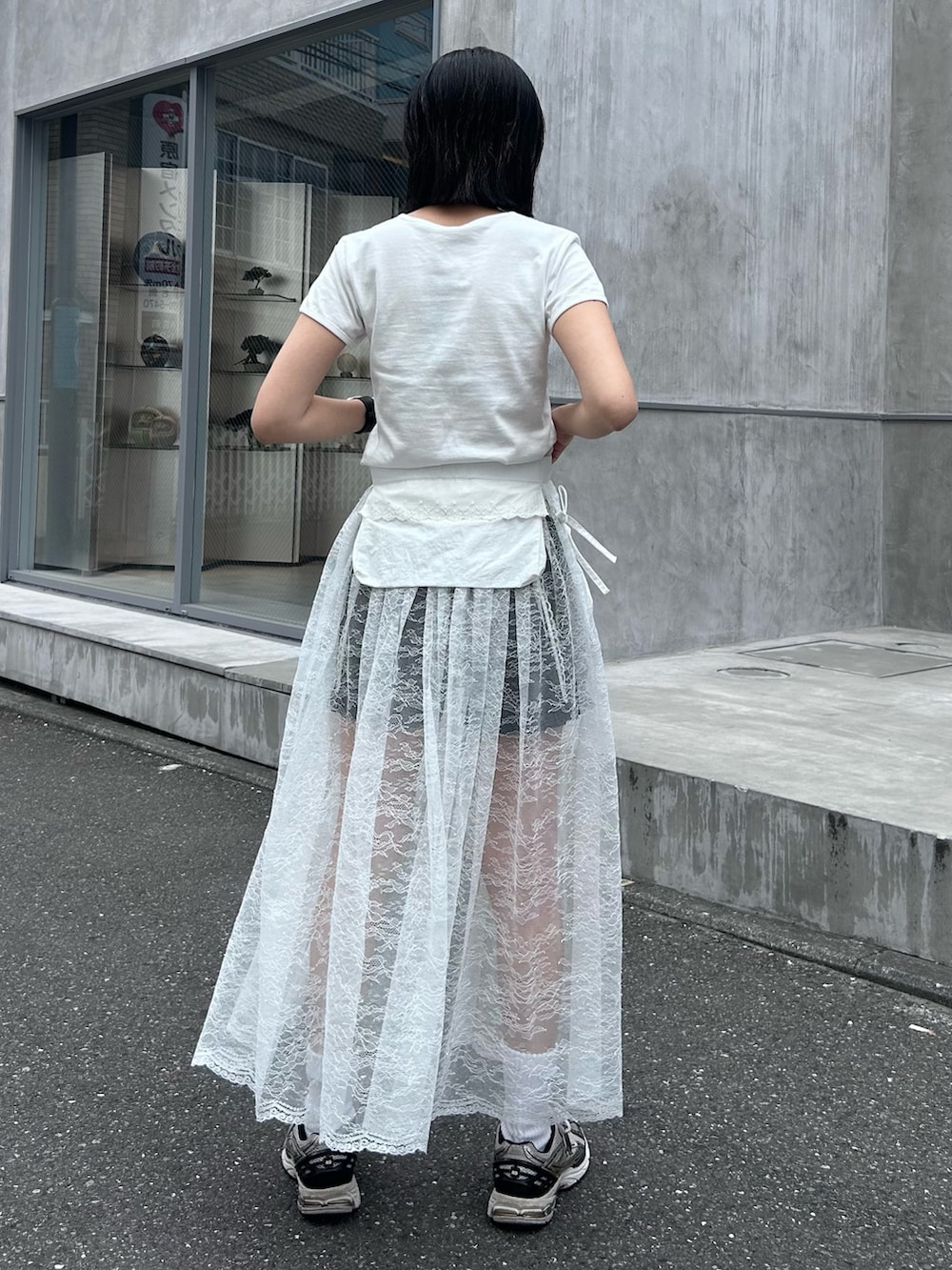 ブラック系のその他パンツ、ホワイト系のスカート、ホワイト系のTシャツ/カットソーを着用したレディースの夏コーディネートの6枚目の写真