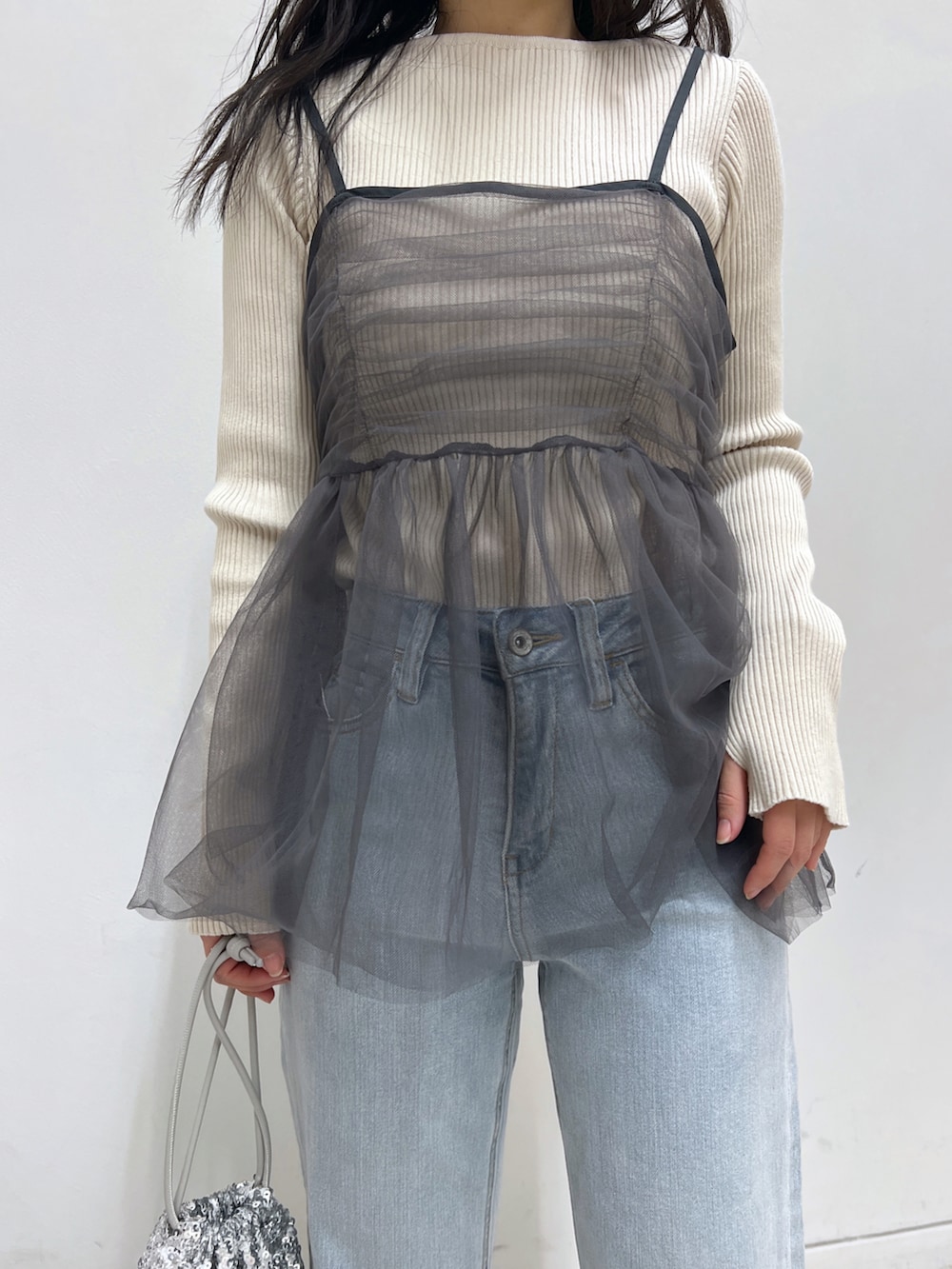 ホワイト系のニット/セーター、グレー系のシャツ/ブラウス、シルバー系のハンドバッグを着用したレディースの冬コーディネートの3枚目の写真