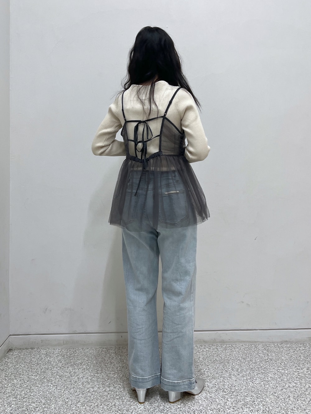 ホワイト系のニット/セーター、グレー系のシャツ/ブラウス、シルバー系のハンドバッグを着用したレディースの冬コーディネートの2枚目の写真