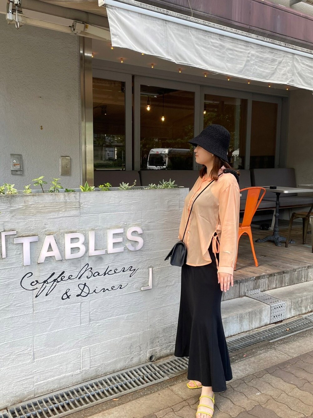 ブラック系のスカート、グリーン系のサンダルを着用したレディースの夏コーディネートの2枚目の写真