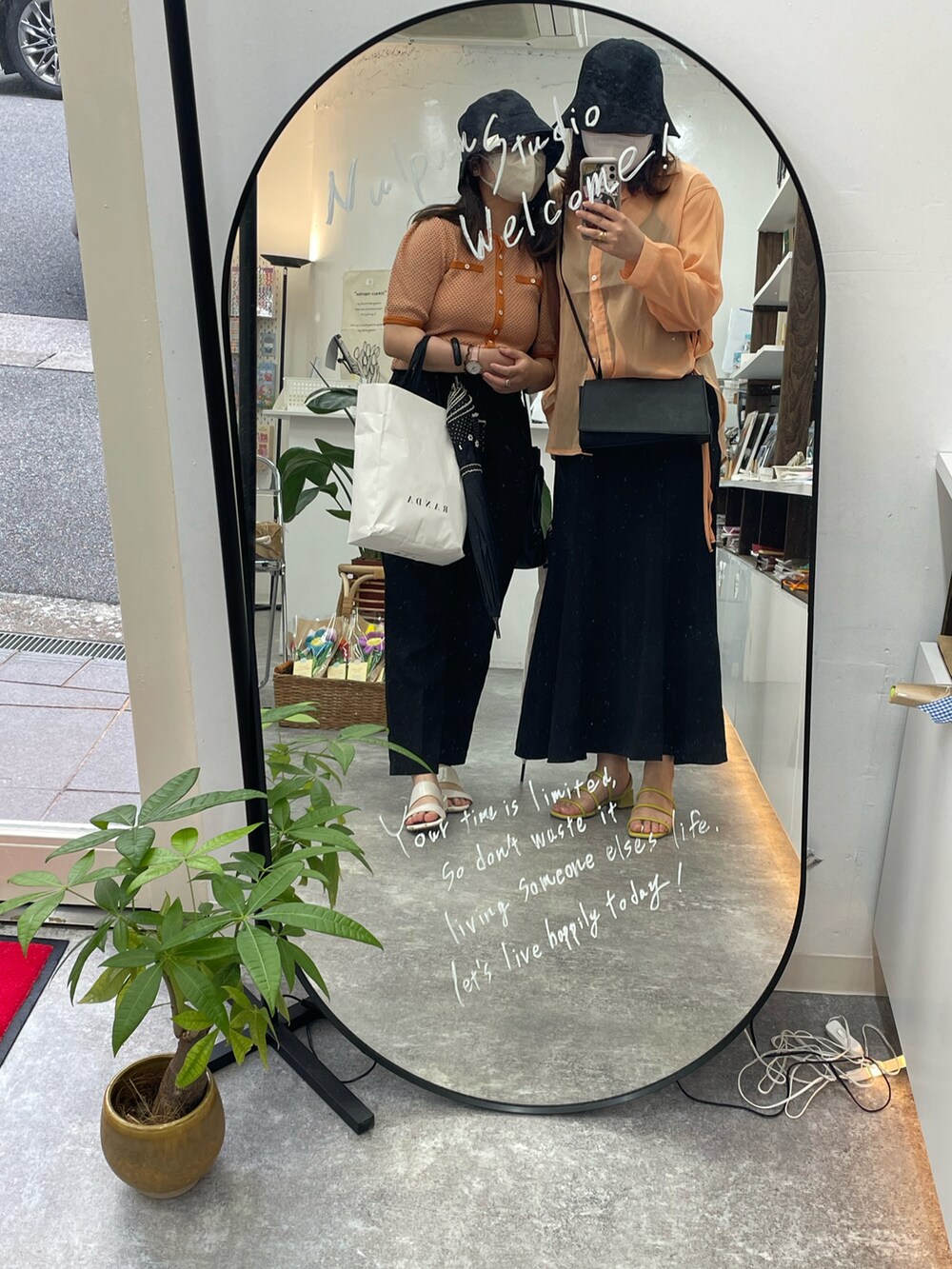 ブラック系のスカート、グリーン系のサンダルを着用したレディースの夏コーディネートの3枚目の写真