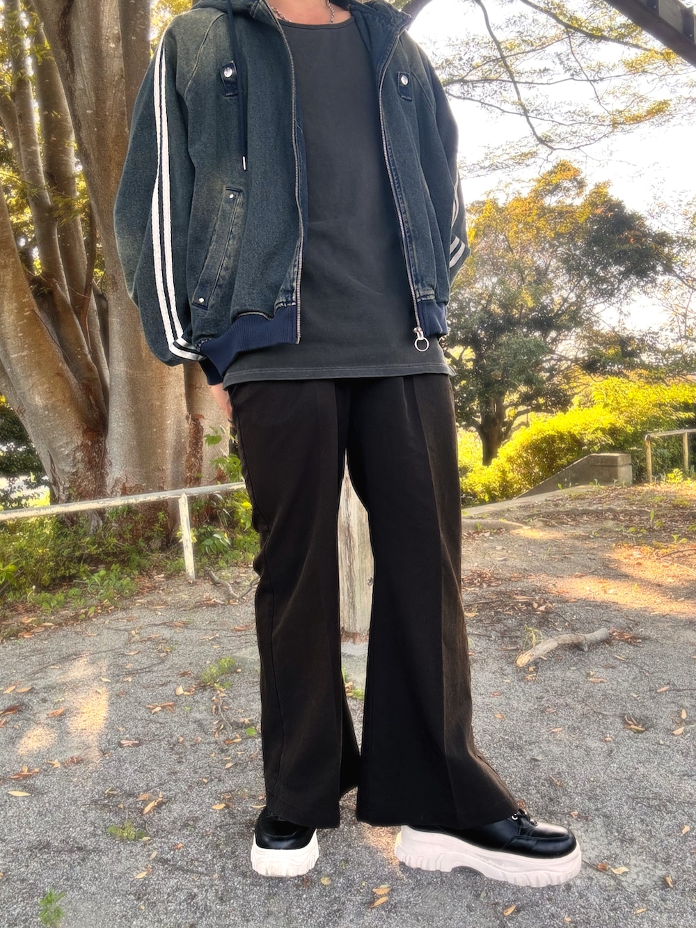 ブラック系のスラックス、ブラック系のスニーカー、ブルー系のタンクトップを着用したメンズの秋コーディネートの3枚目の写真