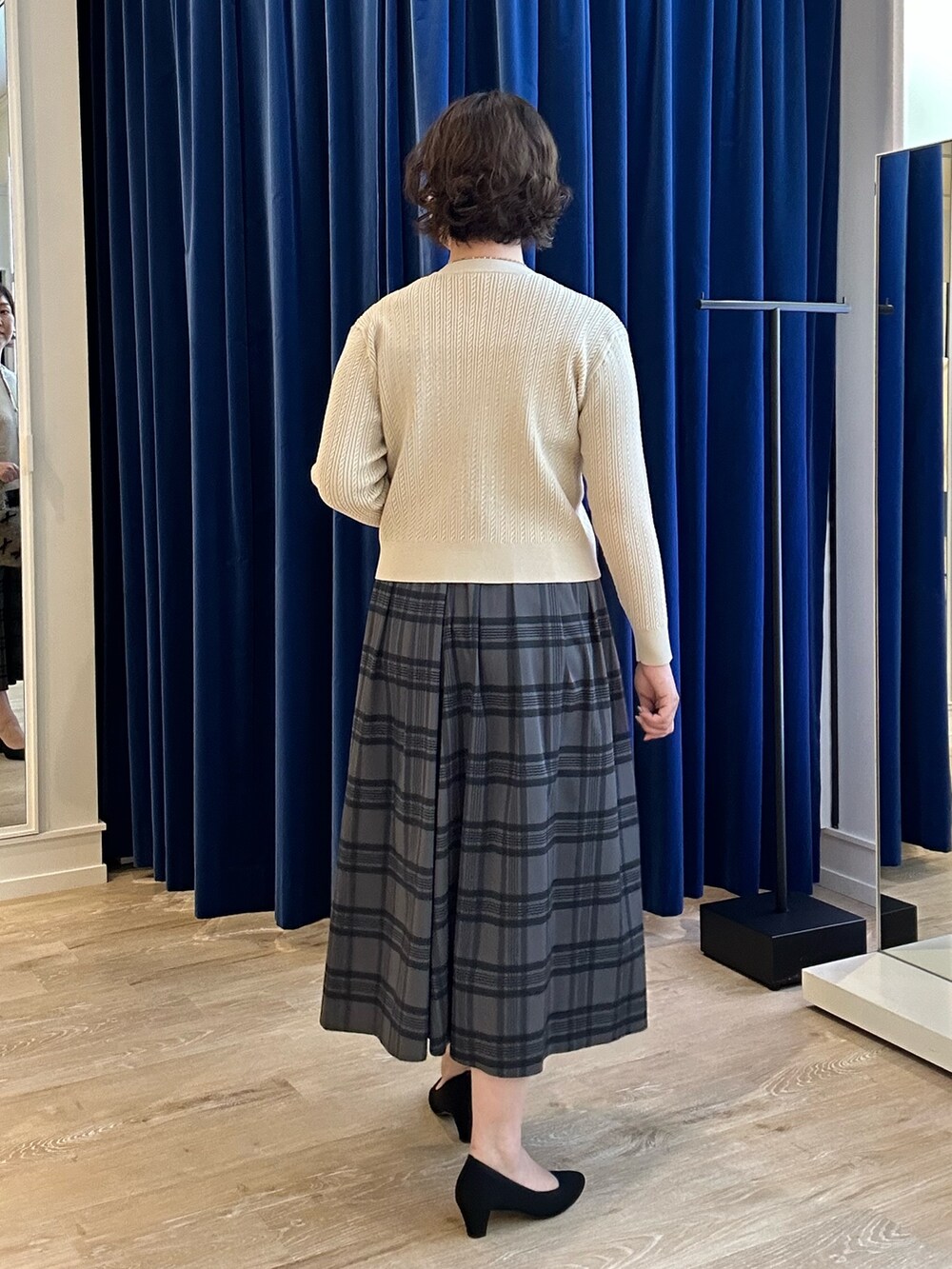 ホワイト系のニット/セーター、ブラウン系のスカートを着用したレディースの秋コーディネートの3枚目の写真