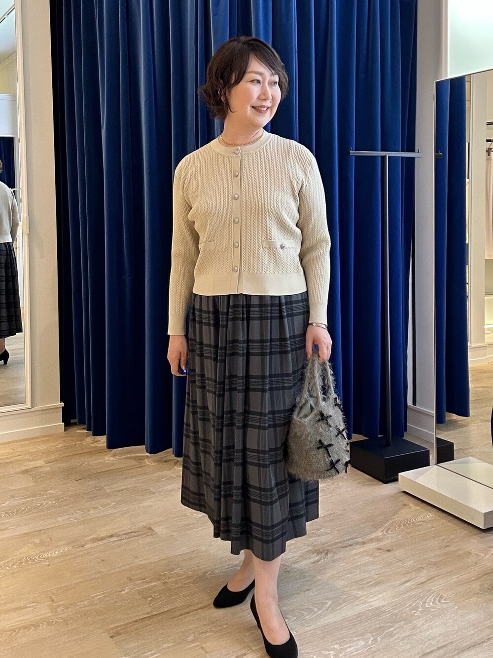 ホワイト系のニット/セーター、ブラウン系のスカートを着用したレディースの秋コーディネートの2枚目の写真