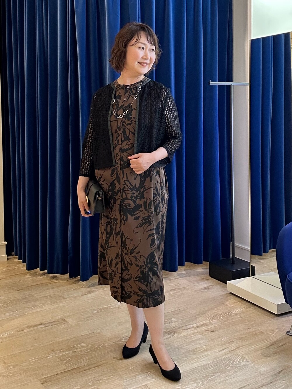 ベージュ系のワンピース、ブラック系のシャツ/ブラウスを着用したレディースの夏コーディネートの6枚目の写真