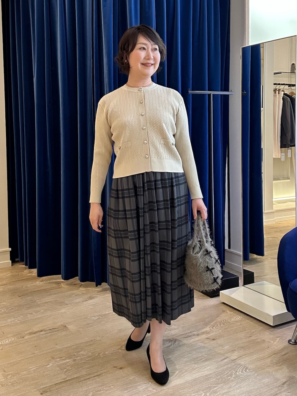 ホワイト系のニット/セーター、ブラウン系のスカートを着用したレディースの秋コーディネートの5枚目の写真