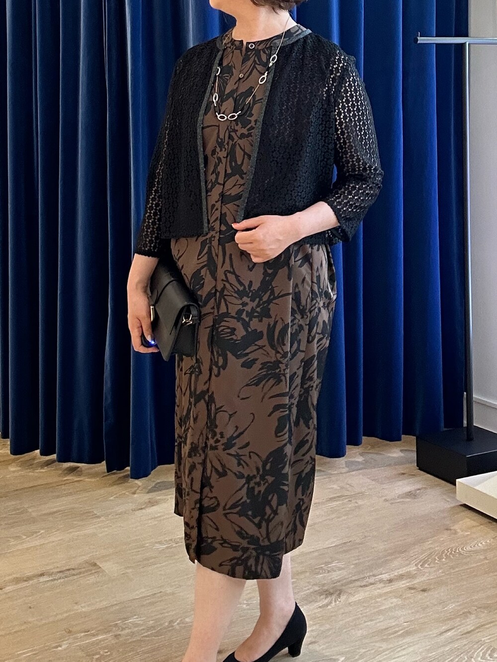 ベージュ系のワンピース、ブラック系のシャツ/ブラウスを着用したレディースの夏コーディネートの3枚目の写真