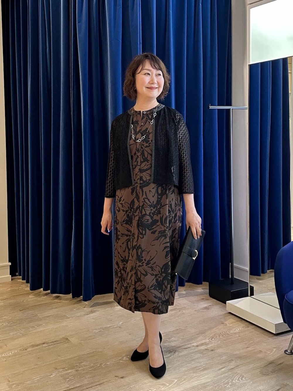 ベージュ系のワンピース、ブラック系のシャツ/ブラウスを着用したレディースの夏コーディネートの2枚目の写真