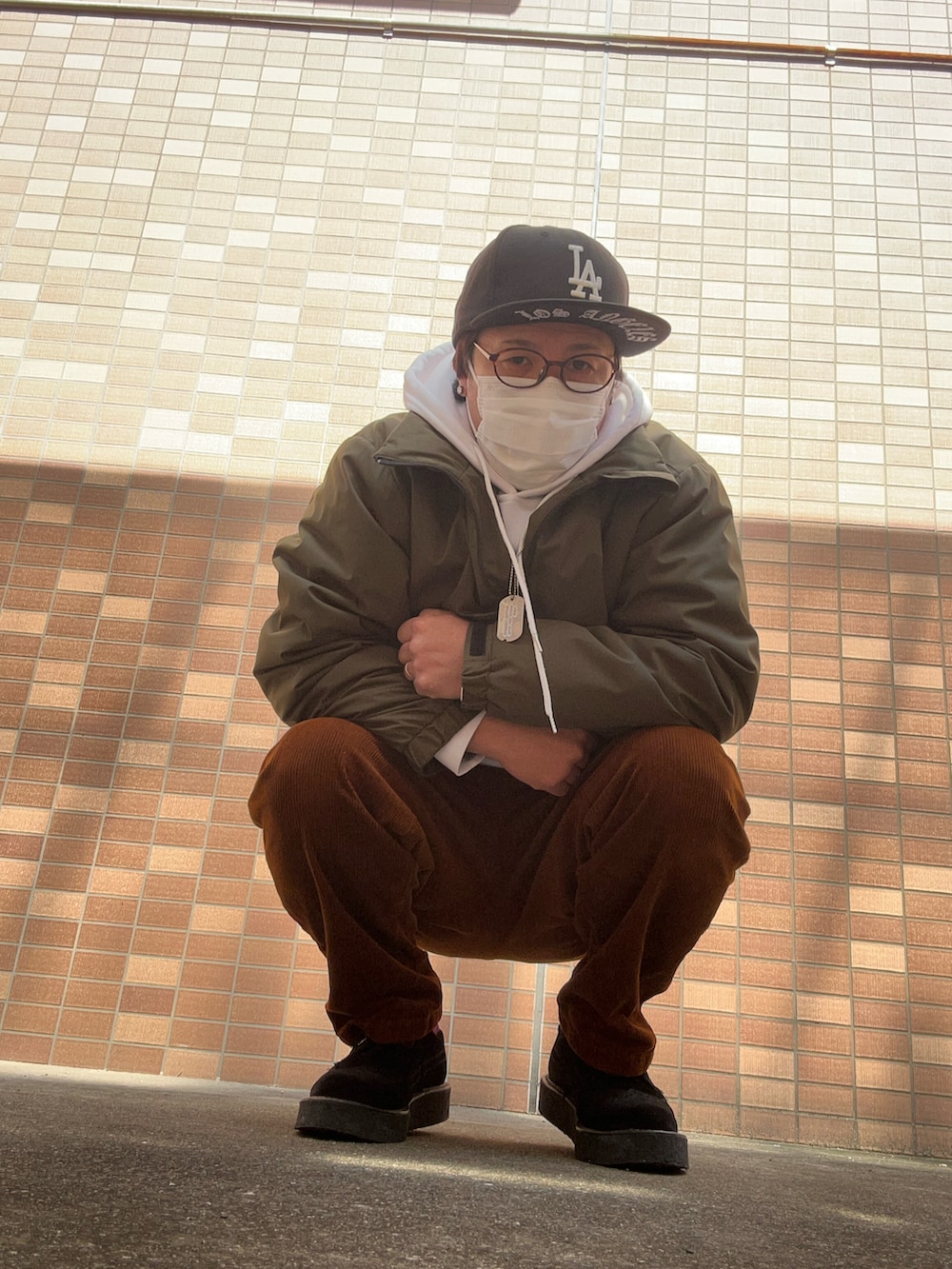 ホワイト系のパーカー、ブラウン系のパンツ、ブラック系のその他シューズを着用したメンズの春コーディネートの4枚目の写真