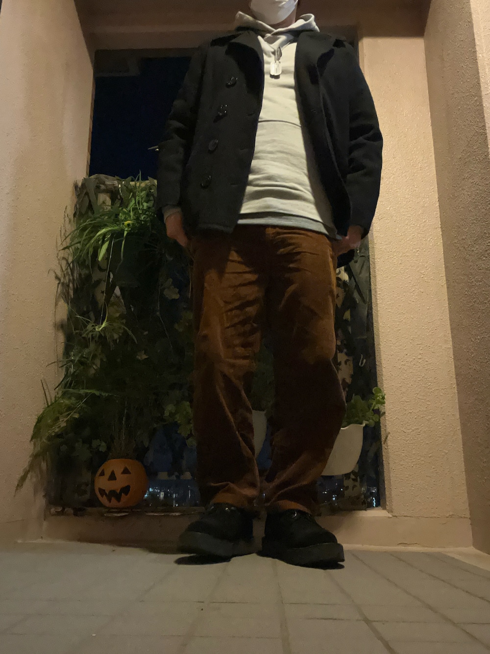 ブラウン系のパンツ、グレー系のパーカー、ブラック系のピーコートを着用したメンズの冬コーディネートの3枚目の写真