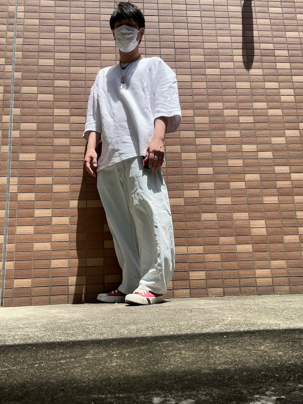 ホワイト系のTシャツ/カットソー、ブルー系のデニムパンツ、レッド系のスニーカーを着用したメンズの春コーディネートの3枚目の写真