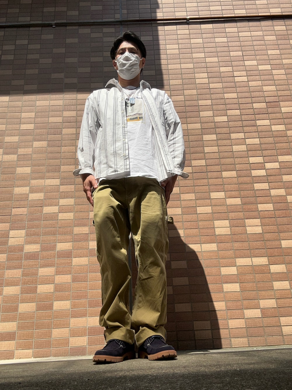 ホワイト系のTシャツ/カットソー、ベージュ系のチノパンツ、ブルー系のモカシン/デッキシューズを着用したメンズの春コーディネートの5枚目の写真