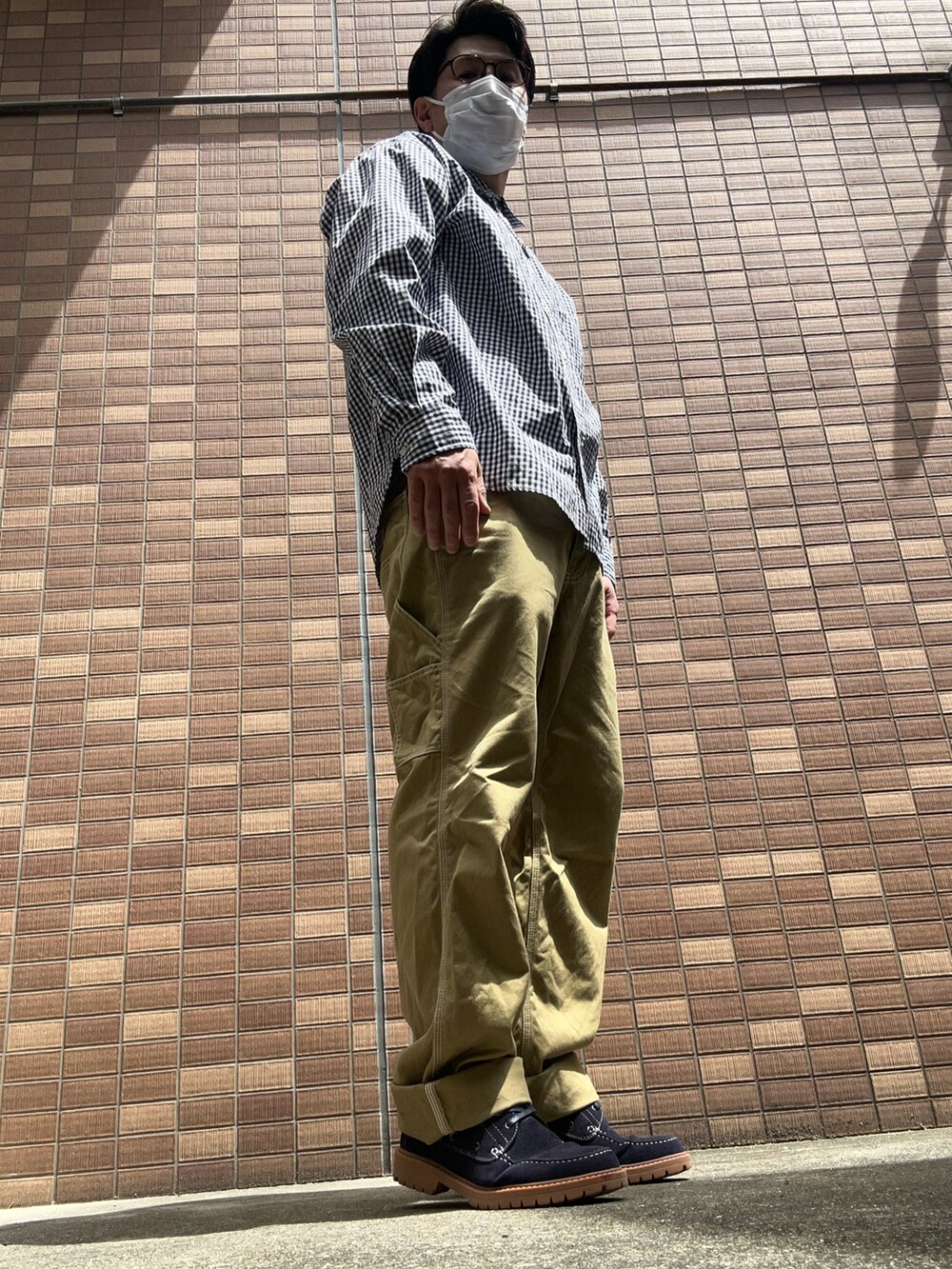 ブルー系のシャツ/ブラウス、ベージュ系のチノパンツ、ブルー系のモカシン/デッキシューズを着用したメンズの春コーディネートの3枚目の写真