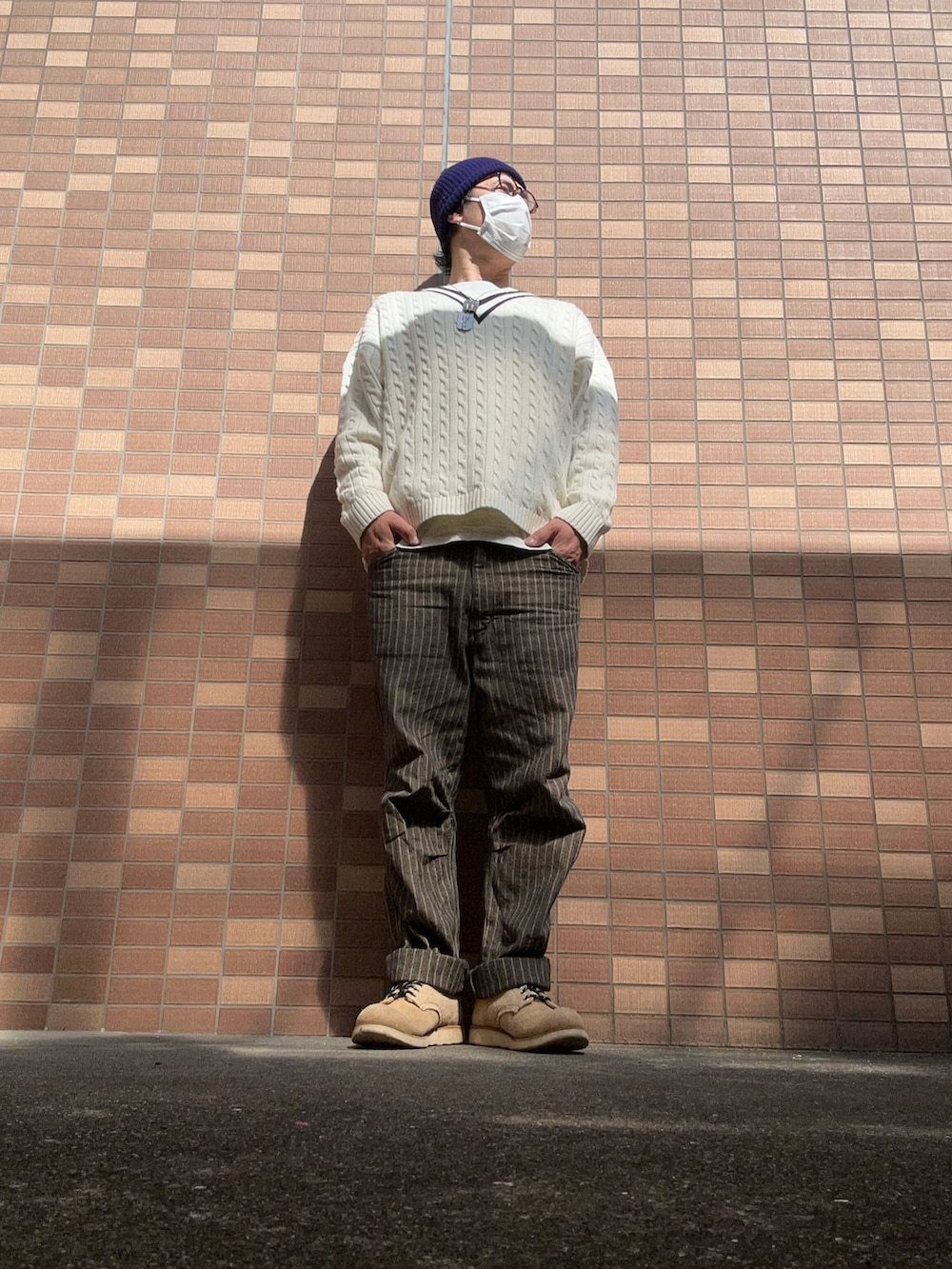 ホワイト系のニット/セーター、グレー系のTシャツ/カットソー、グレー系のパンツを着用したメンズの春コーディネートの2枚目の写真