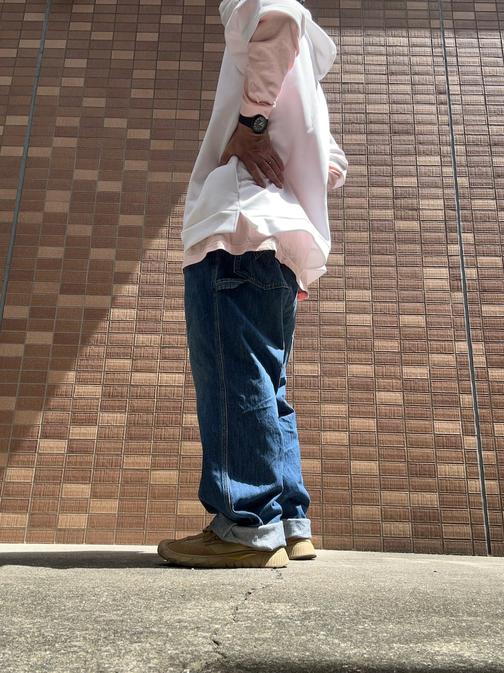 ホワイト系のパーカー、ピンク系のシャツ/ブラウス、ブルー系のデニムパンツを着用したメンズの春コーディネートの4枚目の写真