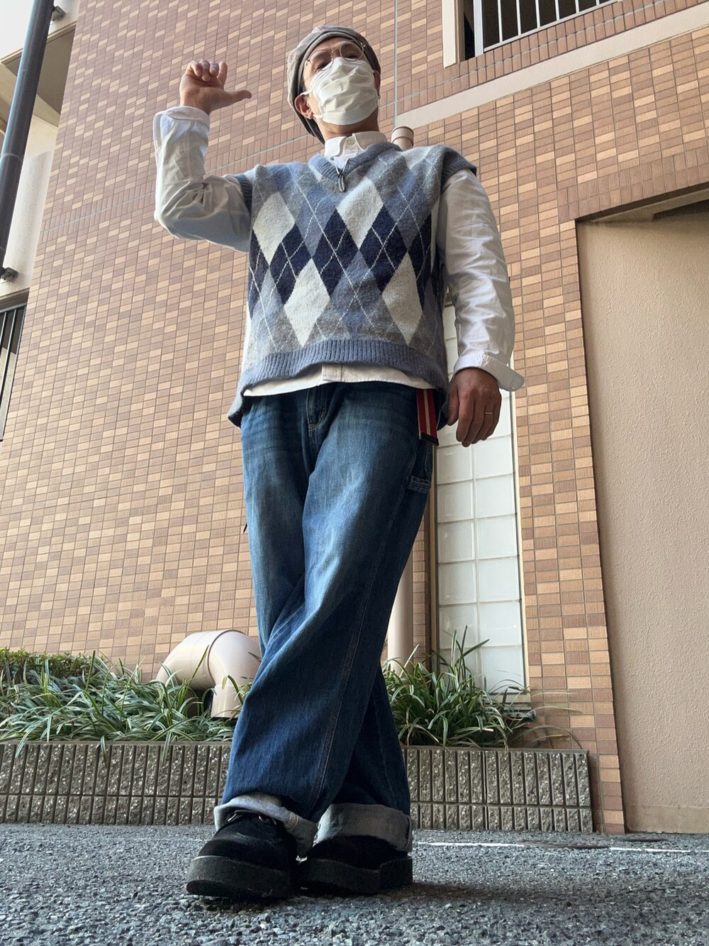 ブルー系のデニムパンツ、ブラック系のシューズ、グレー系のベストを着用したメンズの冬コーディネートの2枚目の写真