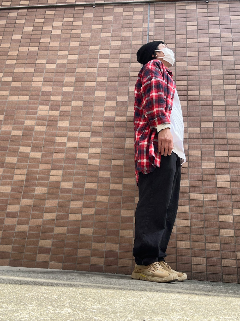 ブラック系のデニムパンツ、ホワイト系のTシャツ/カットソー、ベージュ系のスニーカーを着用したメンズの春コーディネートの2枚目の写真