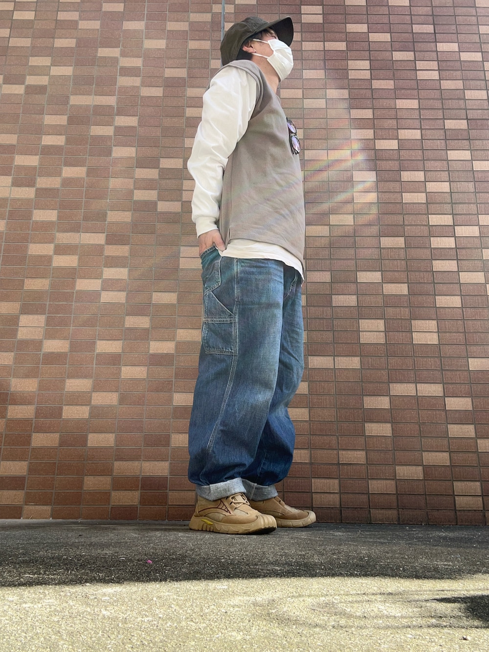 ブルー系のデニムパンツ、ベージュ系のスニーカー、ピンク系のTシャツ/カットソーを着用したメンズの冬コーディネートの2枚目の写真