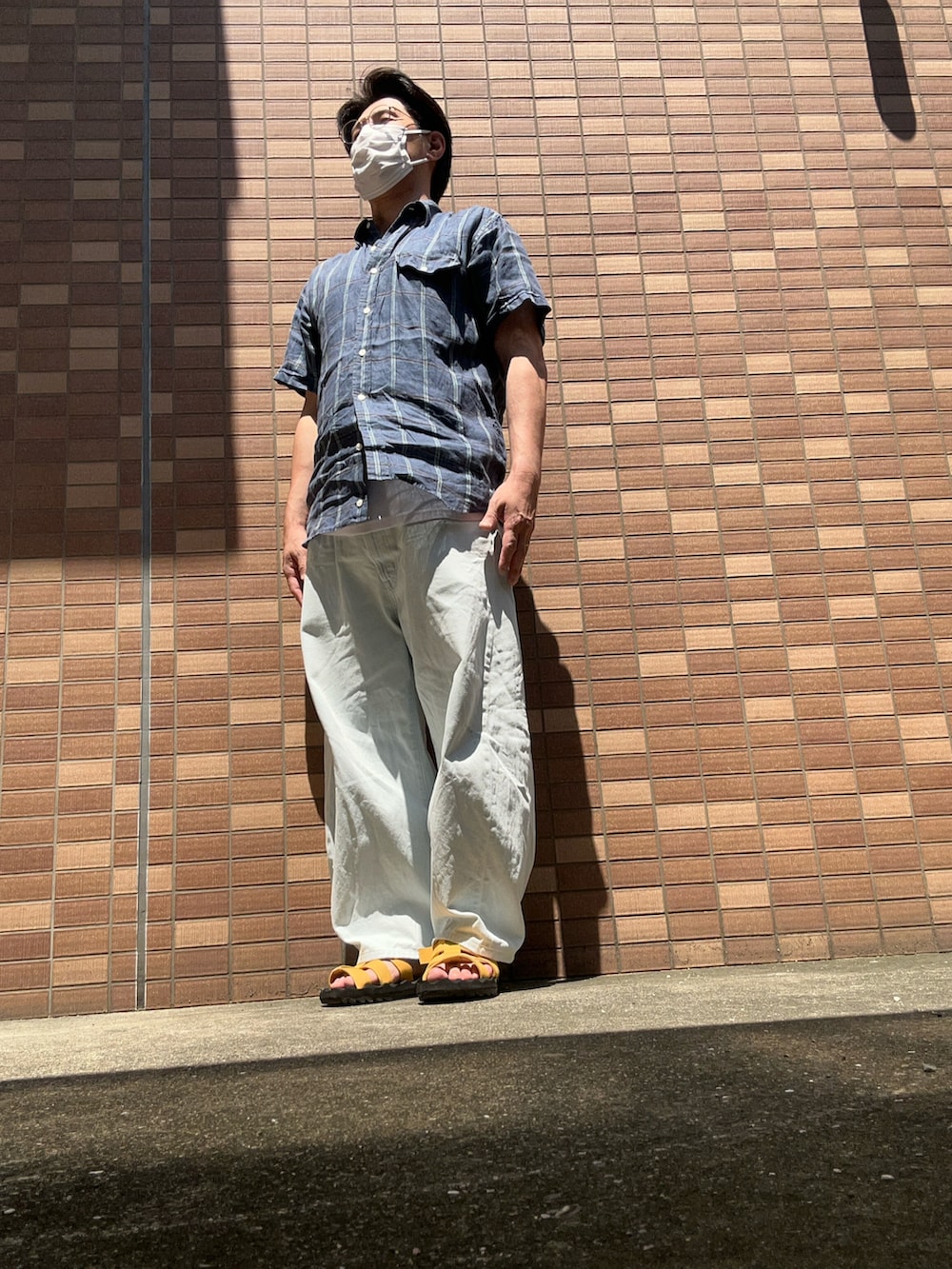 ブルー系のシャツ/ブラウス、ブルー系のデニムパンツ、ホワイト系のタンクトップを着用したメンズの夏コーディネートの3枚目の写真