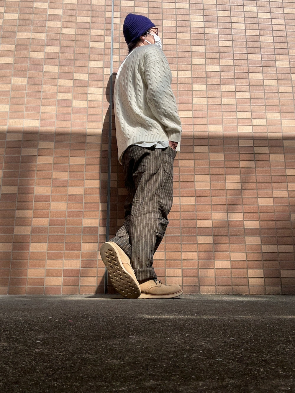 ホワイト系のニット/セーター、グレー系のTシャツ/カットソー、グレー系のパンツを着用したメンズの春コーディネートの3枚目の写真