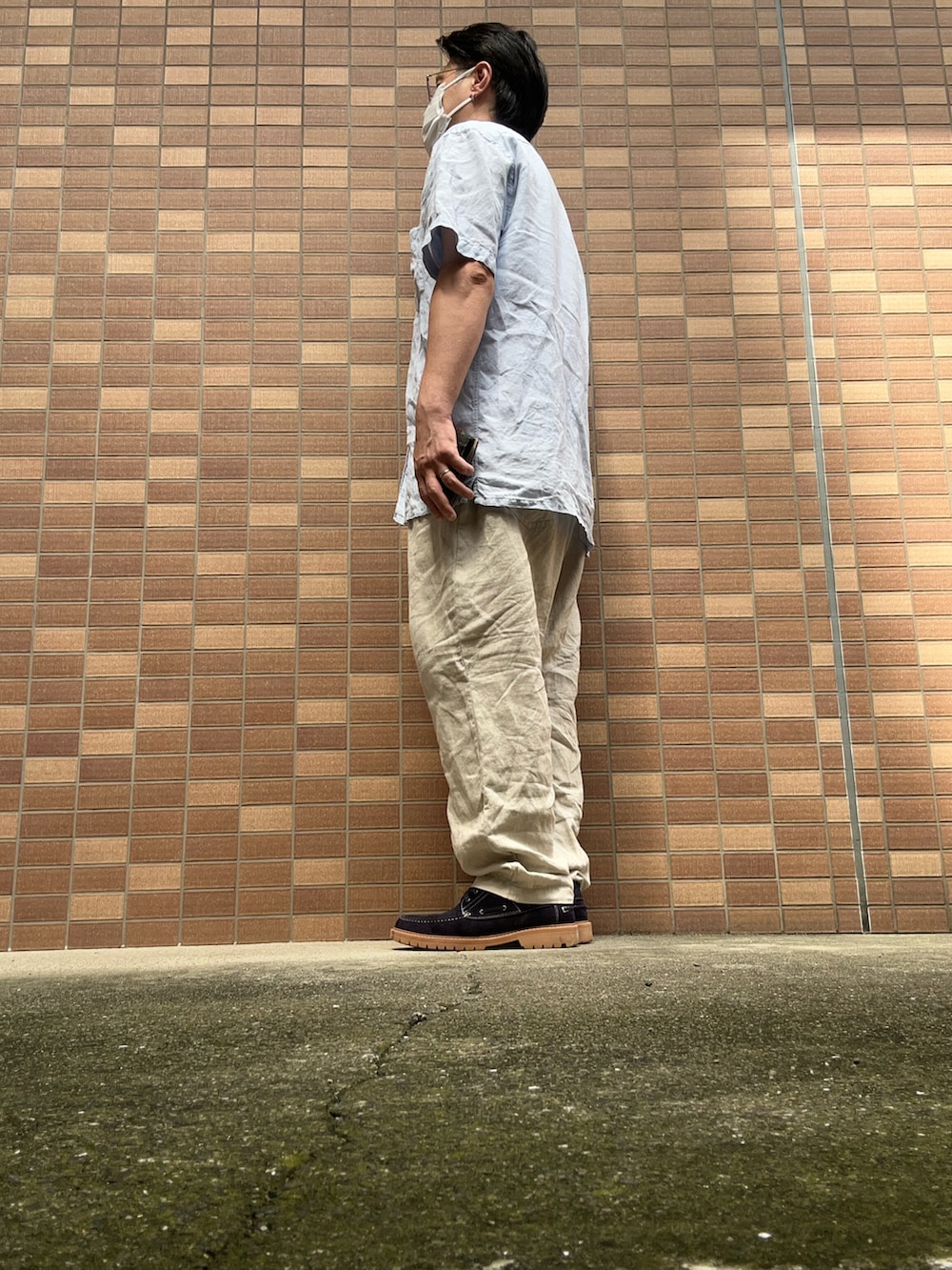 ホワイト系のTシャツ/カットソー、ブルー系のシャツ/ブラウス、ベージュ系のスラックスを着用したメンズの夏コーディネートの4枚目の写真