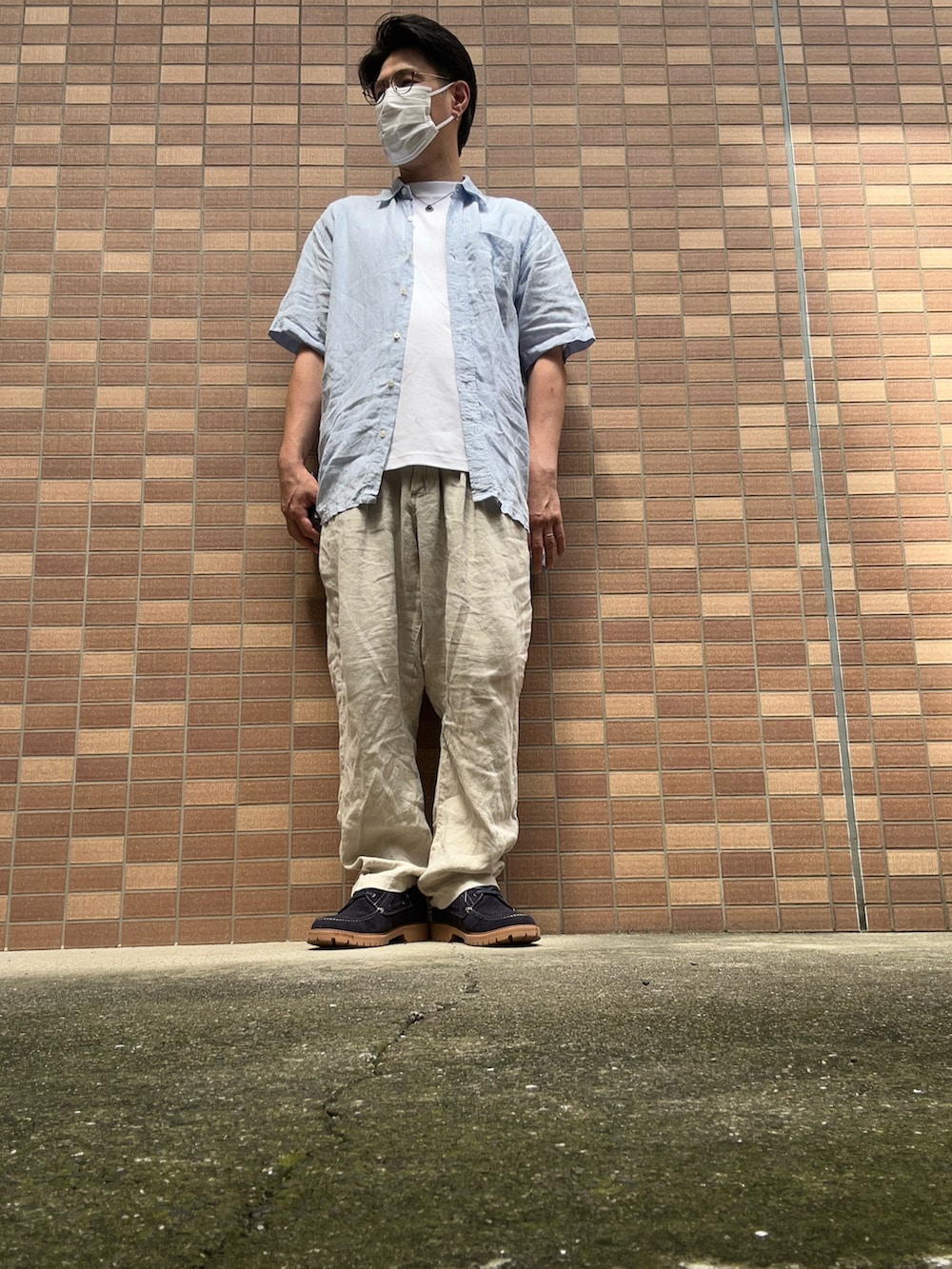ホワイト系のTシャツ/カットソー、ブルー系のシャツ/ブラウス、ベージュ系のスラックスを着用したメンズの夏コーディネートの5枚目の写真