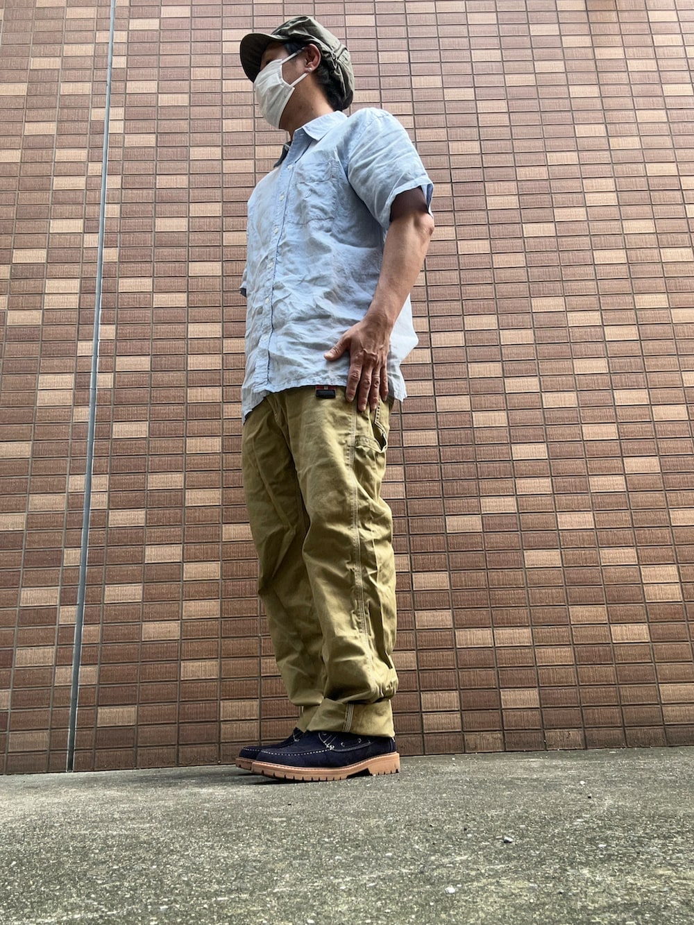 ベージュ系のチノパンツ、ブルー系のモカシン/デッキシューズ、ブルー系のシャツ/ブラウスを着用したメンズの夏コーディネートの2枚目の写真