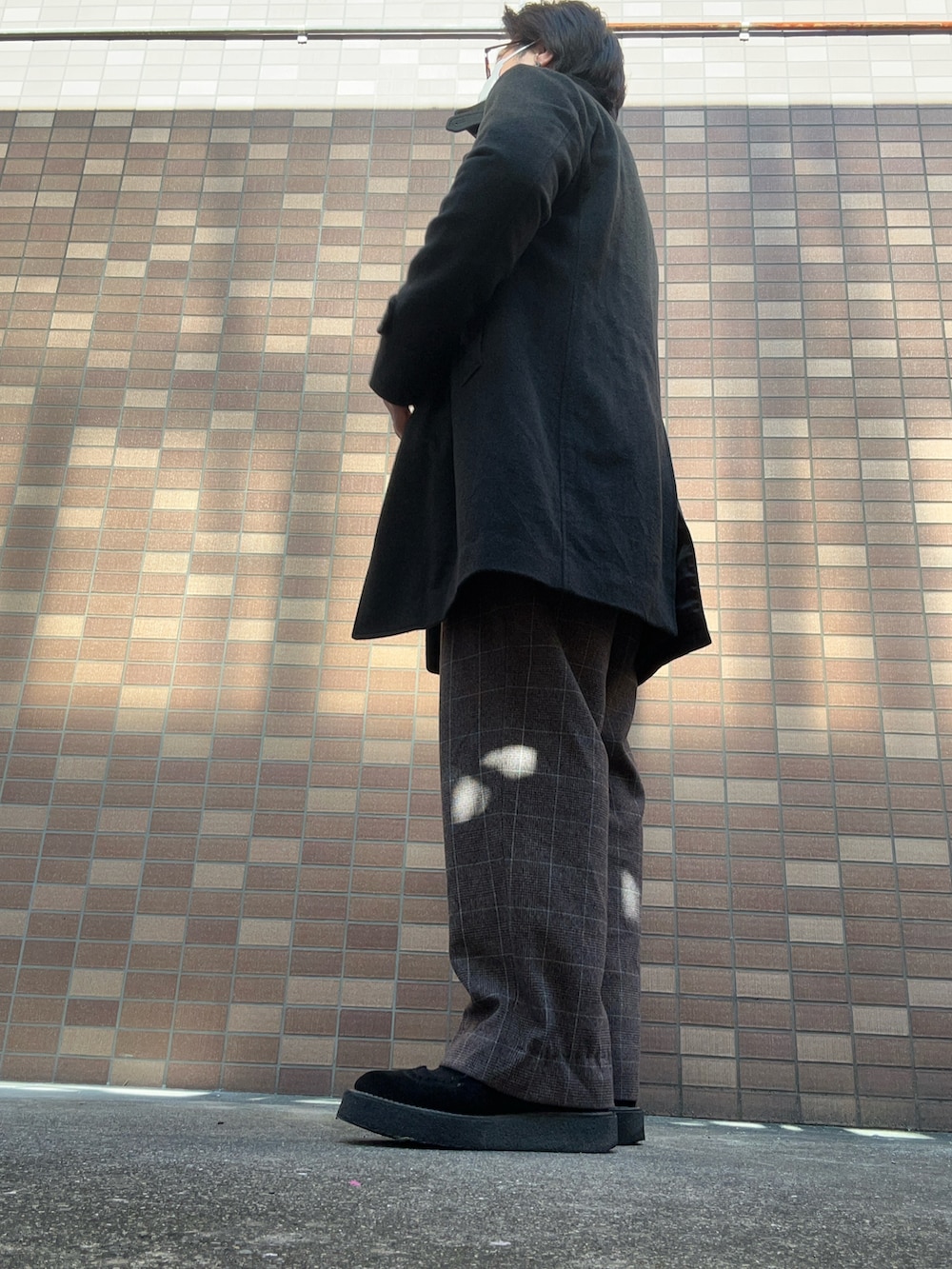 ホワイト系のニット/セーター、グレー系のニット/セーター、ブラウン系のスラックスを着用したメンズの冬コーディネートの3枚目の写真