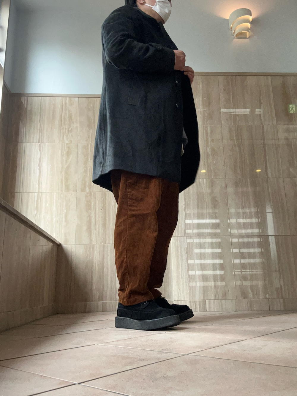 グレー系のニット/セーター、ホワイト系のシャツ/ブラウス、ブラウン系のパンツを着用したメンズの冬コーディネートの2枚目の写真