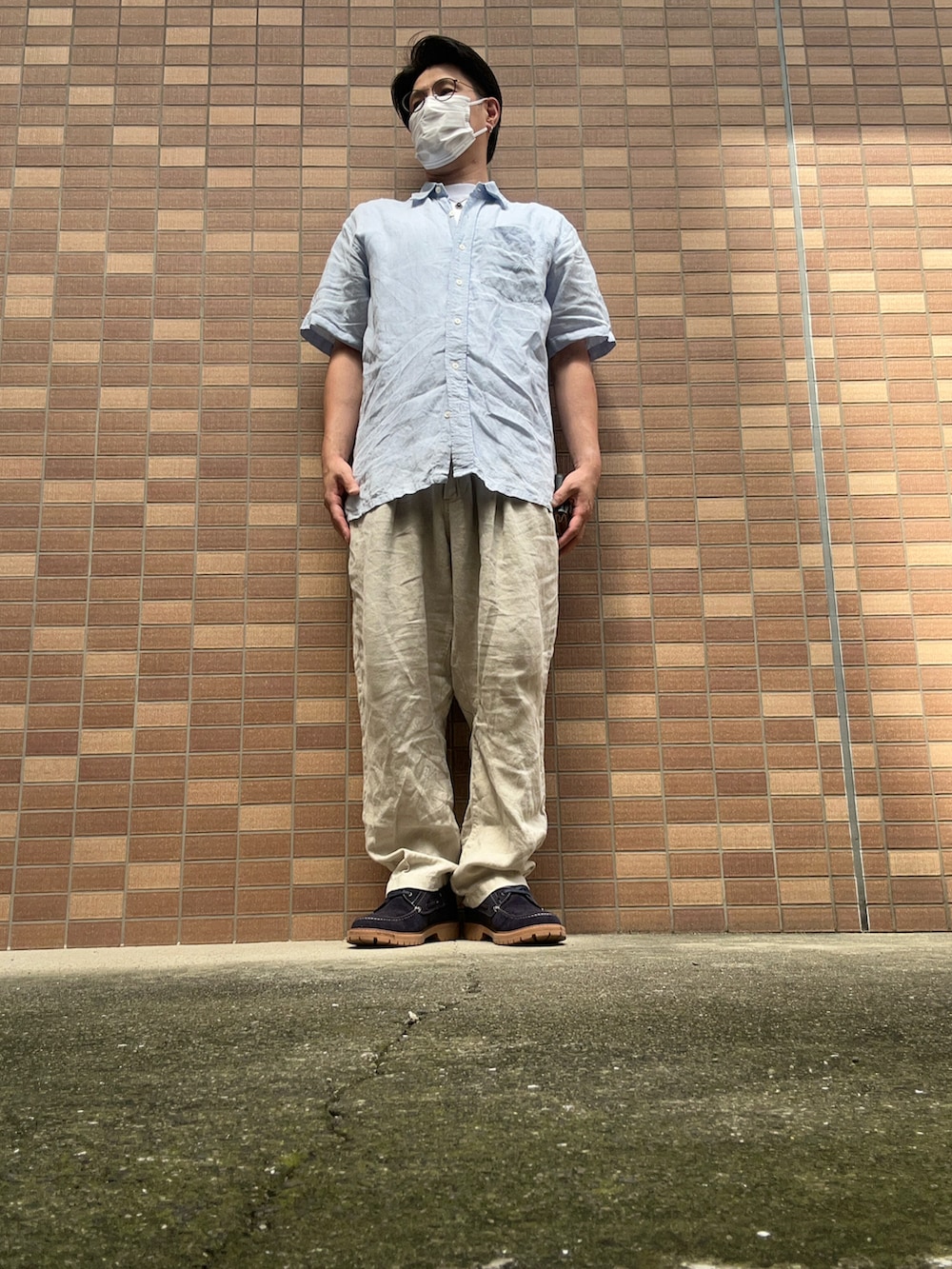ホワイト系のTシャツ/カットソー、ブルー系のシャツ/ブラウス、ベージュ系のスラックスを着用したメンズの夏コーディネートの3枚目の写真